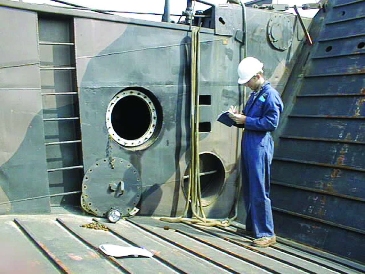 An image of a surveyor writing a report while onboard a damaged vessel