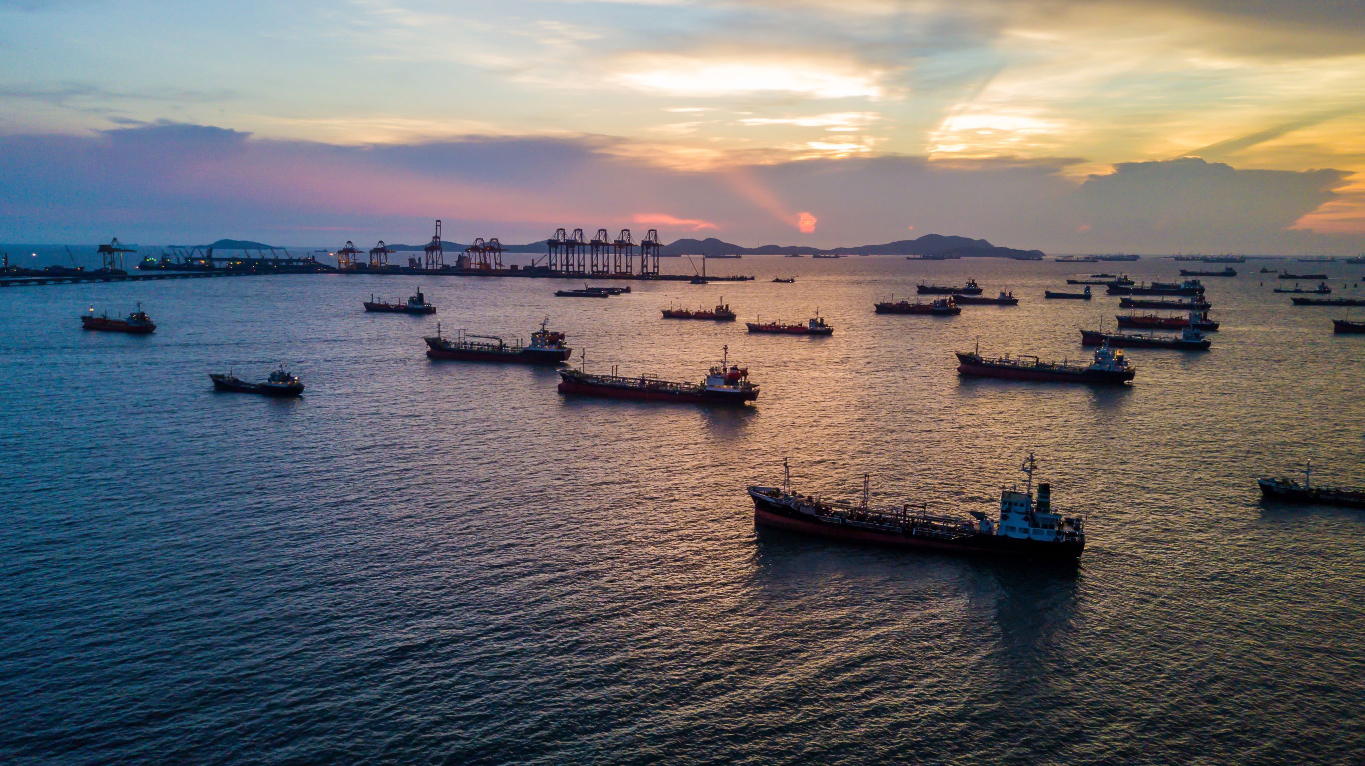 A picture of about 20 boats sitting in a marina at night